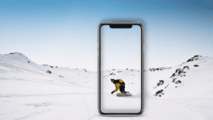 Handy macht ein Foto von einem Snowboarder in der Winterlandschaft